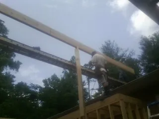 Carpenter setting a ridge beam over a new addition frame — Ice Dam Removal by Roofing Brothers in Lannon
