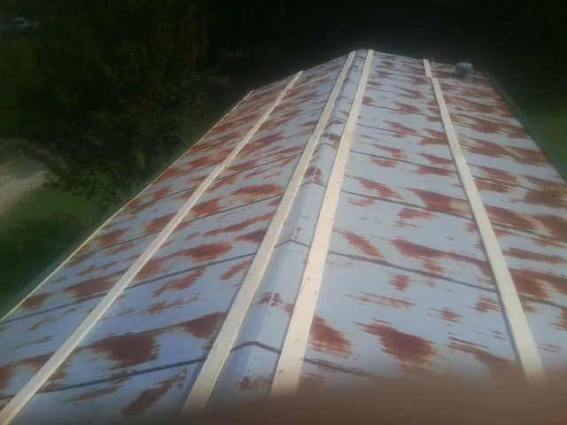 Rusted metal roof panels with new wood purlins before replacement — Storm Damage Roof Repair in Lannon by Roofing Brothers