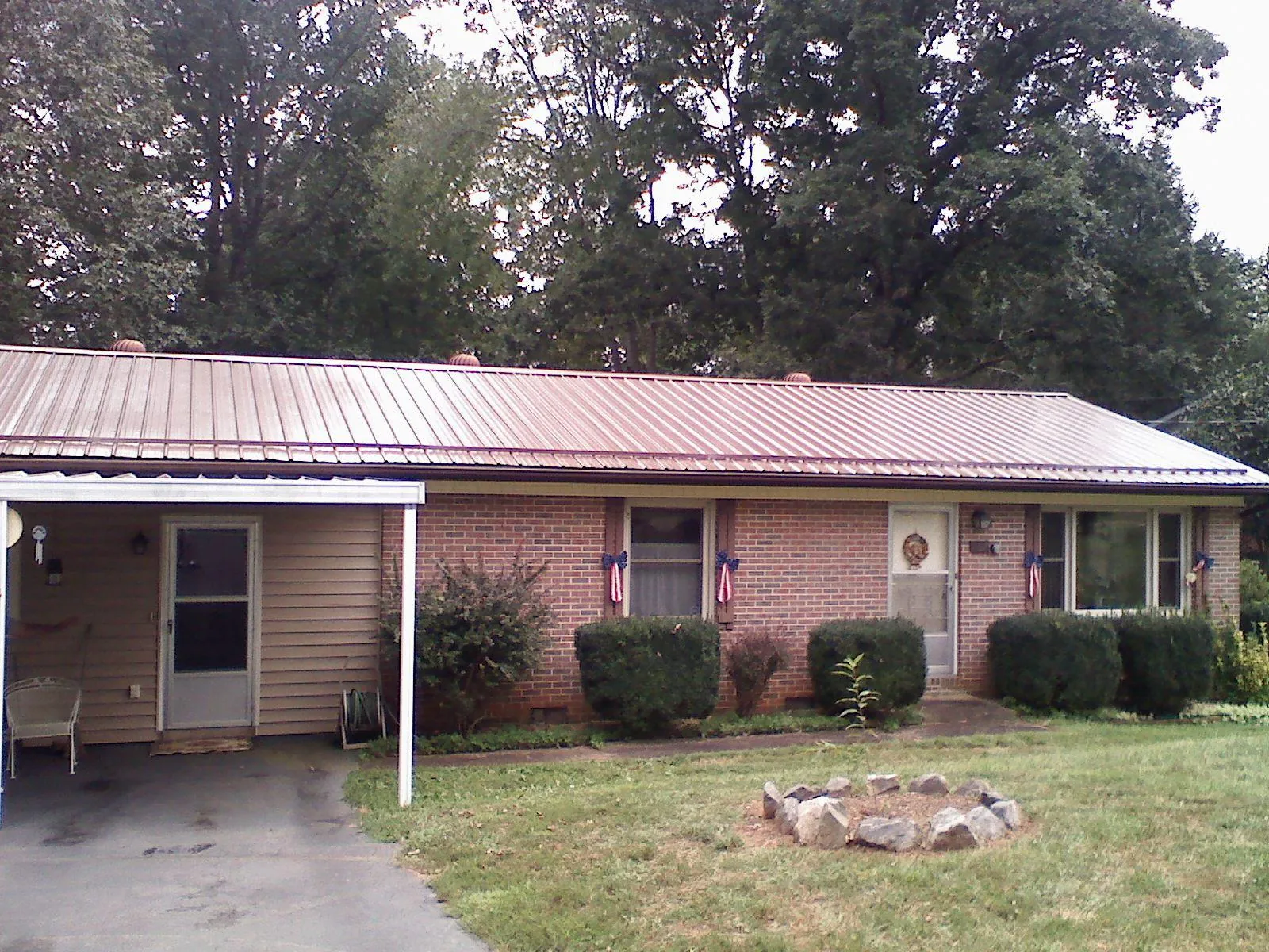Bronze metal roof and carport on a brick ranch home — Roof Repair work by our crew in Lannon