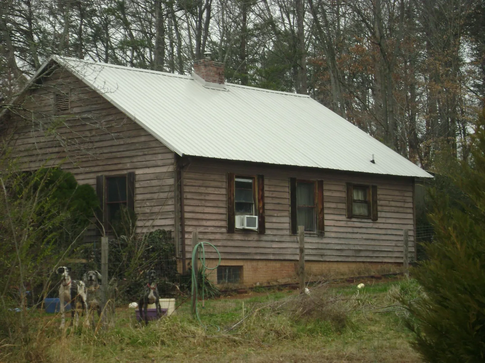 White metal roof on an old wood sided farmhouse, from a Metal Roof Installation job in Lannon